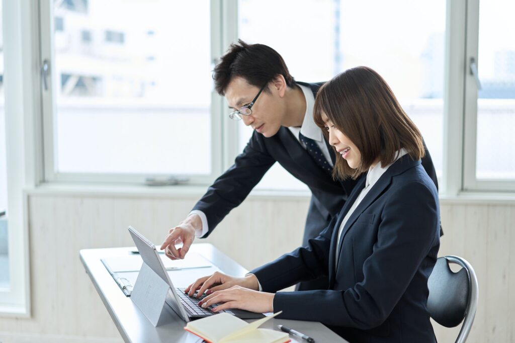 Asian businessman teaching his subordinate's computer